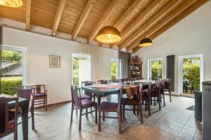 a dining room with tables and chairs and windows at Ferienhaus Eifellandhaus in Zweifelscheid