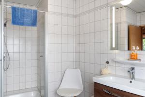 a white bathroom with a toilet and a sink at Ferienhaus Poth in Wangerland +21 photos
