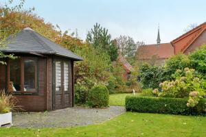 a small building in a yard with a garden at Ferienhaus Poth in Wangerland