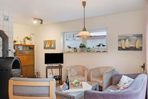 a living room with a couch and chairs and a tv at Ferienhaus Poth in Wangerland