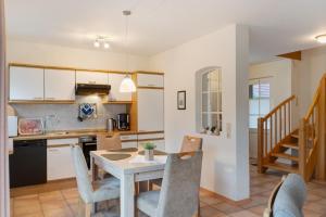 a kitchen and dining room with a table and chairs at Ferienhaus Poth in Wangerland
