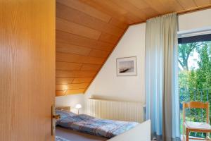 a bedroom with a bed and a window at Ferienhaus Poth in Wangerland