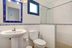 a bathroom with a toilet and a sink and a mirror at Casa Vivo in Famara +18 photos