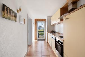 a kitchen with a hallway leading to a door at Birkethof Teichblick in Grimoldsried