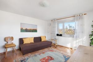 a living room with a couch and a window at Birkethof Teichblick in Grimoldsried