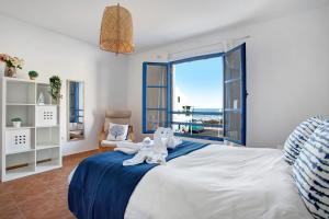 a bedroom with a large white bed and a window at Casa Vivo in Famara