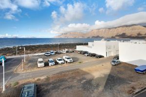 a parking lot with cars parked next to the ocean at Casa Vivo in Famara