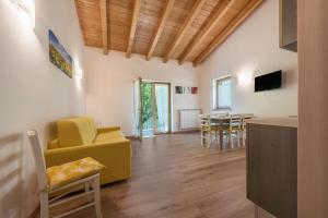 a living room with a yellow couch and a table at Nonno Bigi Girasole in Tremosine Sul Garda
