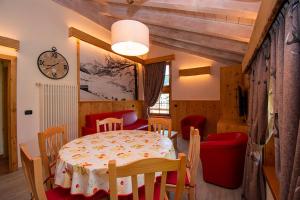 a dining room with a table and chairs and a clock at Chalet Galli Trilocale in Livigno