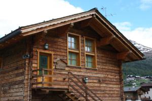 a log cabin with a porch and windows at Chalet Galli Trilocale in Livigno