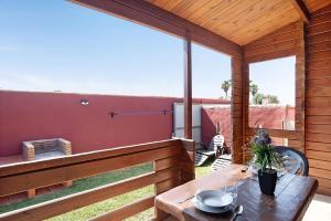 a patio with a table and a large window at Casa Juana Madera in Zahora