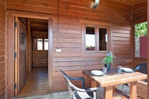 a wooden porch with a wooden table and chairs at Casa Juana Madera in Zahora