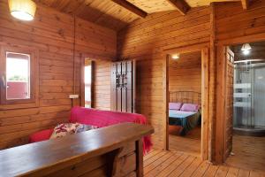 a log cabin with a red couch and a bed at Casa Juana Madera in Zahora +18 photos