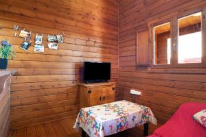 a room with wooden walls and a tv and a table at Casa Juana Madera in Zahora