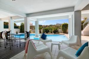 a patio with a table and chairs and a swimming pool at Villa Rosana in Albufeira