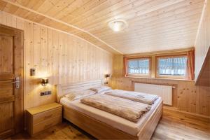 a bedroom with a bed in a wooden room at Jelerhof in Gsies