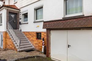 a person standing next to a brick building with a garage at Traumschmiede in Bad Emstal