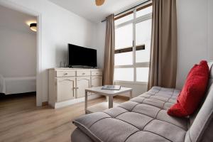 a living room with a couch and a tv at Apartamento Playa Morro Jable 1a in Morro del Jable