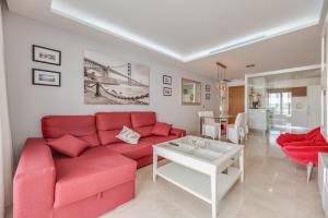 a living room with a red couch and a table at Acogedor apartamento 2 dormitorios in Marbella
