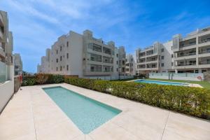 an apartment complex with a swimming pool and two buildings at Acogedor apartamento 2 dormitorios in Marbella