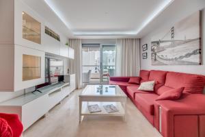 a living room with a red couch and a table at Acogedor apartamento 2 dormitorios in Marbella