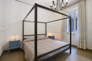a bedroom with a canopy bed and two night stands at Il Cortiletto 21 in Marsala