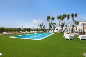 a yard with a swimming pool and green grass at Quinta Alegre Tavira T1 in Luz de Tavira