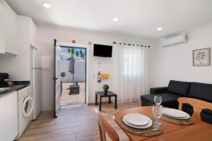 a kitchen and a living room with a table and a couch at Quinta Alegre Tavira T1 in Luz de Tavira