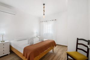 a white bedroom with a bed and a chair at Quinta Alegre Tavira T1 in Luz de Tavira +16 photos