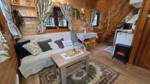 a living room with a couch and a stove at Chatki Małgorzatki in Bystre