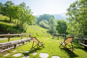 two chairs sitting in the grass near a fence at Civico 1 in Marmora +4 photos