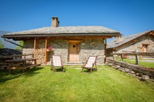 a stone house with two chairs in front of it at Civico 1 in Marmora