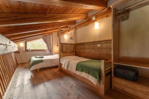 a log cabin bedroom with two beds and a window at Civico 1 in Marmora