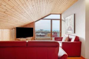 a living room with a red couch and a flat screen tv at Haus Höhensonne in Höchenschwand
