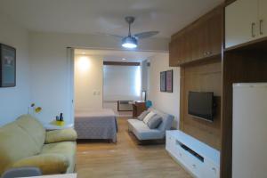 Sala de estar con sofá, cama y TV en Loft Felipe De Oliveira, en Río de Janeiro