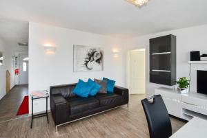 a living room with a leather couch and a television at Domicilio Azzurro in Lindau