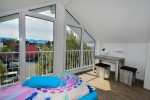 a bedroom with a balcony with a bed and a desk at Domicilio Azzurro in Lindau +8 photos