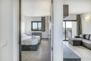 a bedroom with a bed and a living room with a couch at Giuliano Superior 1 para 4 personas in Empuriabrava
