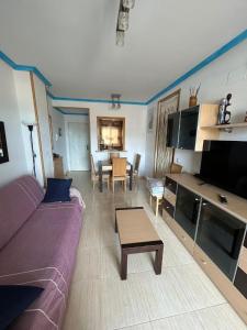 a living room with a purple couch and a table at Nasay Magic World in El Borseral