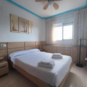 a bedroom with a bed with towels on it at Nasay Magic World in El Borseral +8 photos