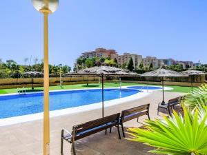 a pool with benches and umbrellas next to a building at Nasay Magic World in El Borseral