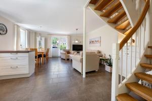 a living room with a staircase and a dining room at Ferienhaus Huus Alex in Böhl