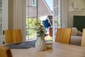 a vase with flowers sitting on top of a table at Ferienhaus Huus Alex in Böhl