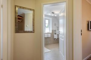 a bathroom with a mirror and a walk in shower at Ferienhaus Huus Alex in Böhl +29 photos