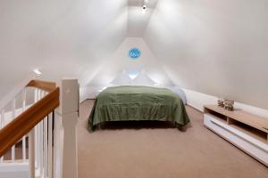 a bedroom with a green bed in a attic at Ferienhaus Huus Alex in Böhl