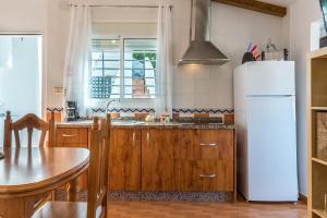 a kitchen with wooden cabinets and a white refrigerator at Apartamento a pie de playa in Benajarafe +17 photos