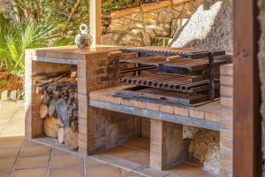 a stone fireplace in a patio with a brick wall at Miravall in Puigpunyent
