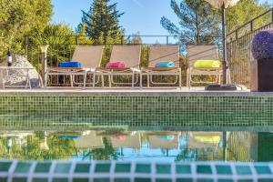 a group of chairs sitting next to a swimming pool at Miravall in Puigpunyent
