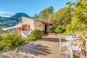 a patio with a table and chairs in front of a house at Miravall in Puigpunyent