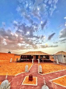 a large building in the middle of a desert at Merzouga Infinity Dunes Camp in Merzouga